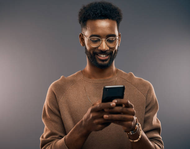 a man wearing a light-brown shirt holding a mobile